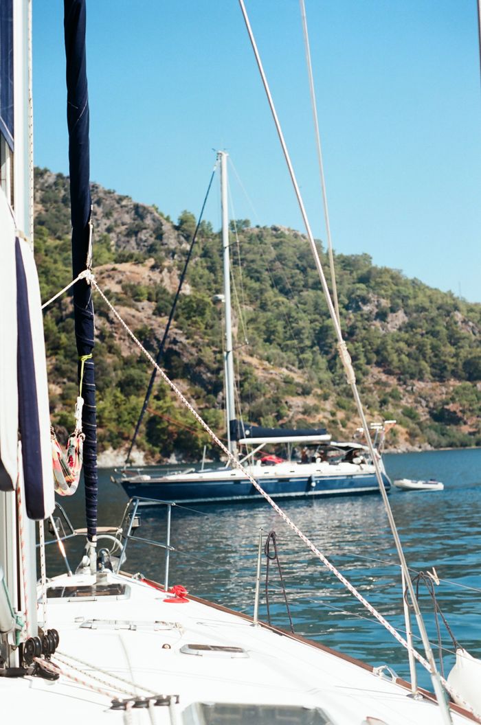 cursos Calm boating experience on a sailboat with beautiful coastal view under clear blue skies.