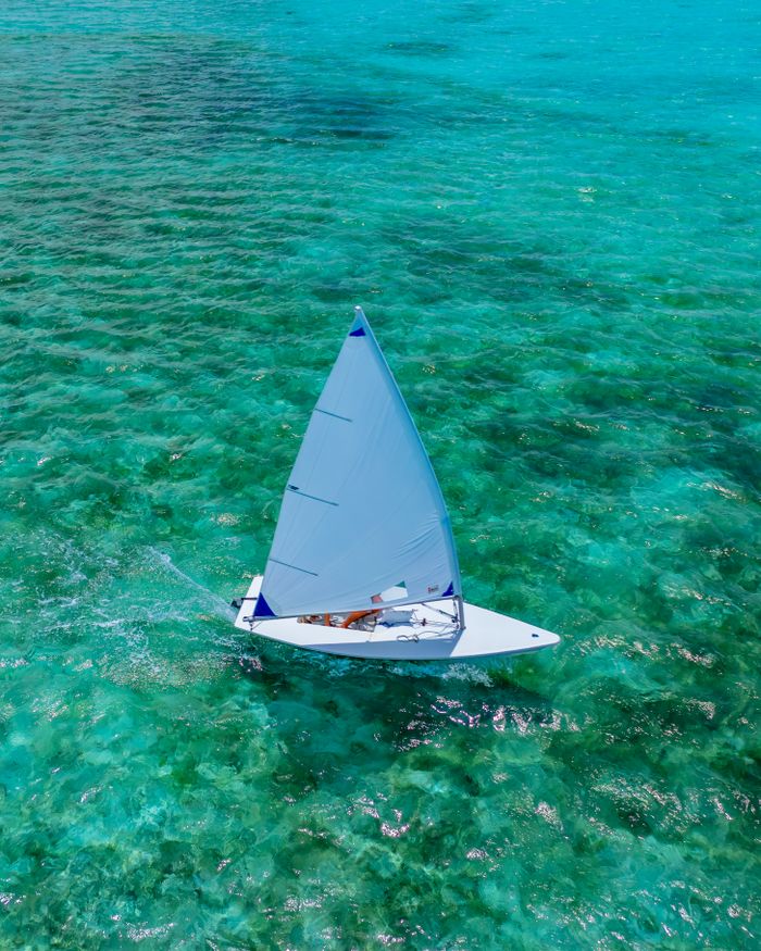 nosotros Drone view of a sailboat gliding on turquoise sea during a sunny day, perfect for summer adventures.