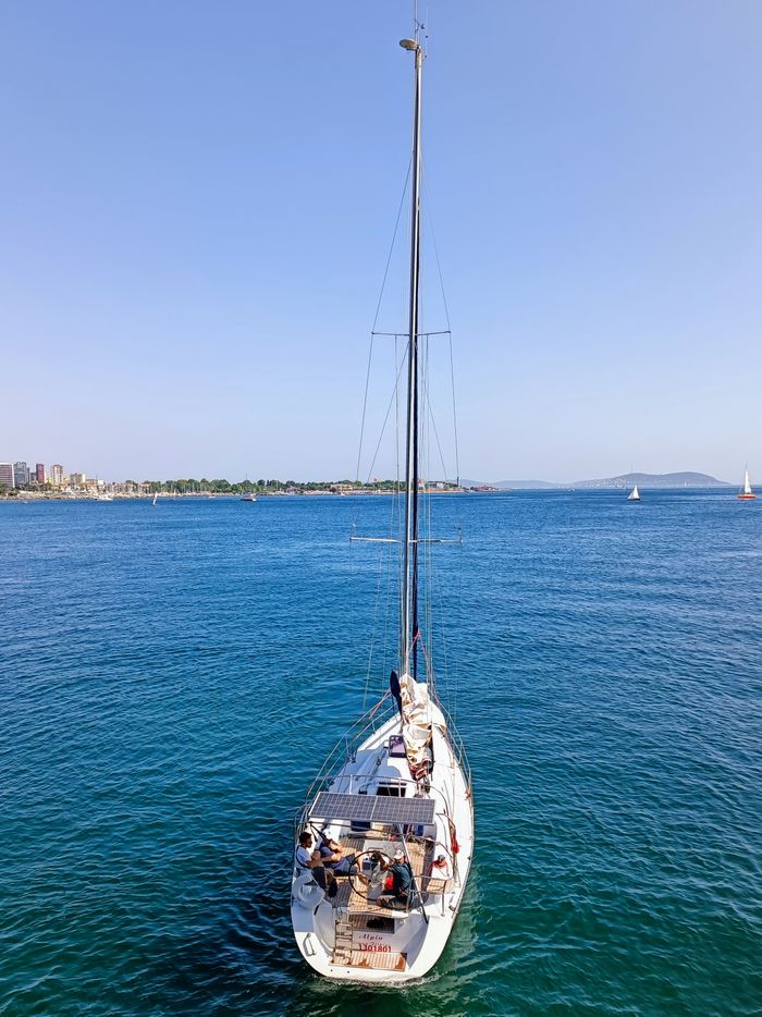 nosotros A serene view of a sailboat navigating the vibrant blue waters near Istanbul, Türkiye.