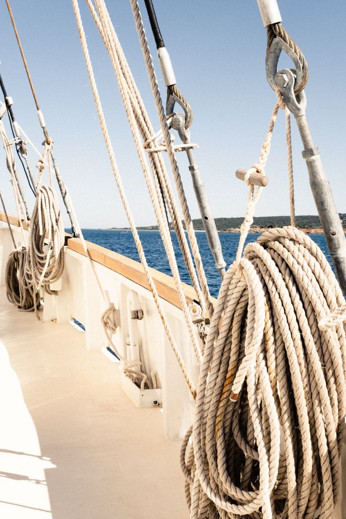 cursos Close-up of coiled rope on a sailboat deck, showcasing marine craftsmanship.